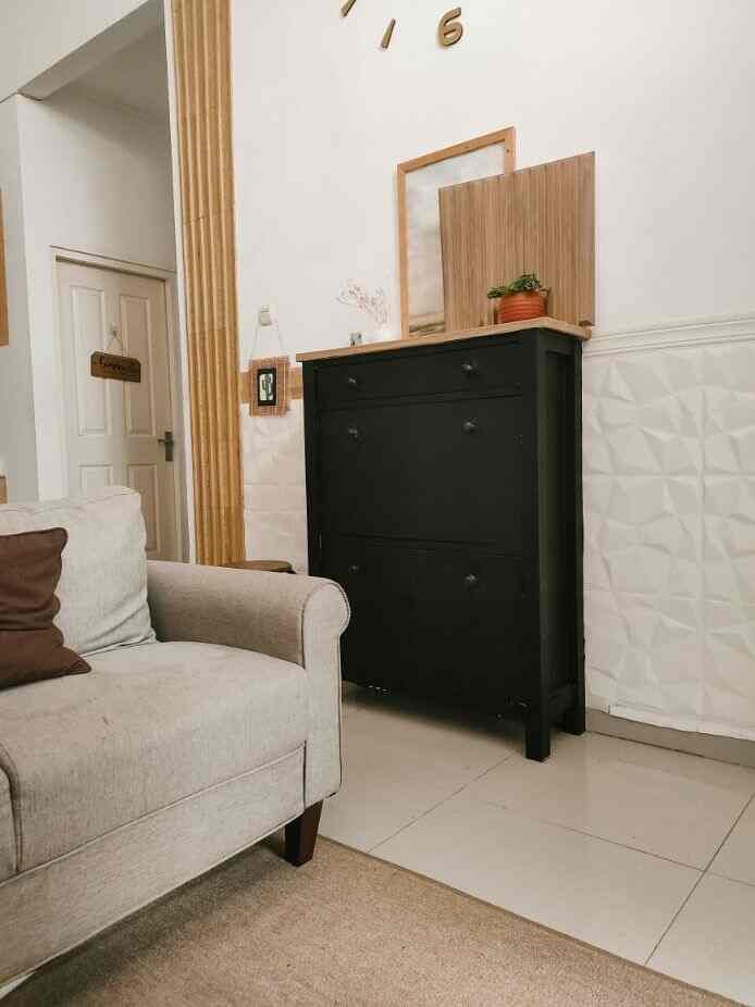 Beige-toned living room featuring a beige sofa on the left and a black dresser on the center-right, showcasing simple, natural Japandi style decor
