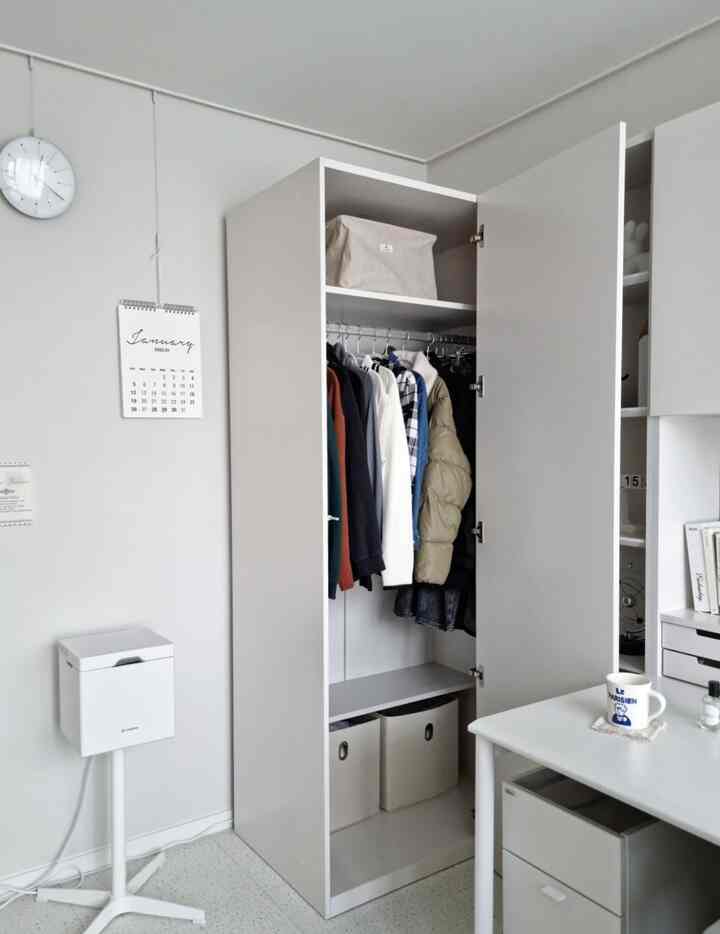 明るい白を基調とした小さな部屋のクローゼットとデスクが配置されたシンプルで整然としたインテリア