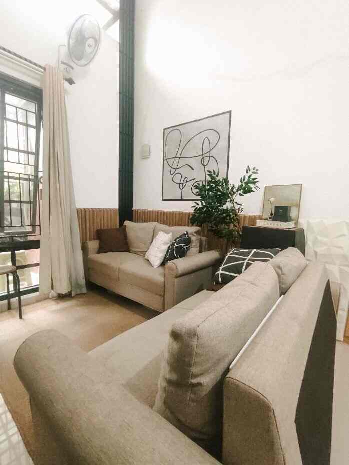 White and beige toned living room featuring two sofas and a plant with a cozy natural atmosphere