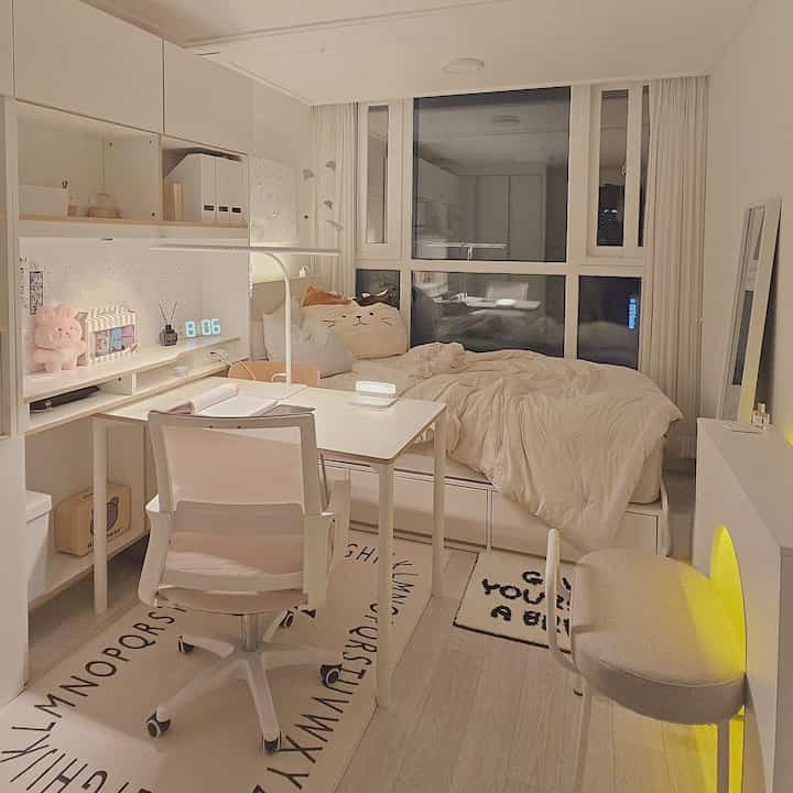 温かみのあるベージュとホワイトのトーンでまとめられた中学生の部屋、ベッドとL字型デスクが整然と配置された印象的な空間