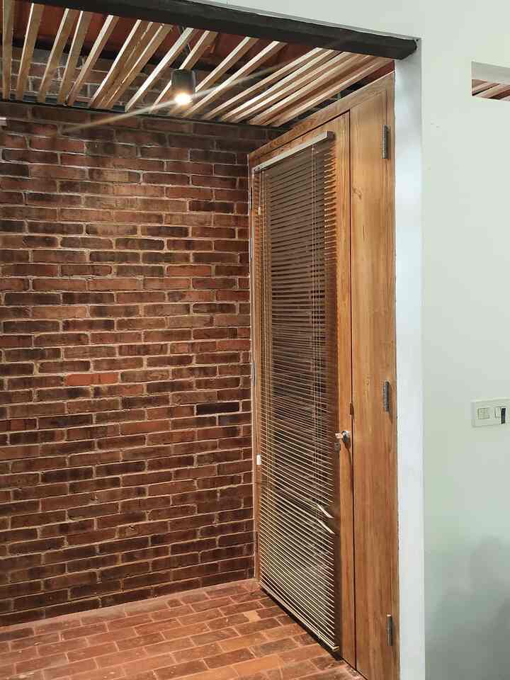 Untuk masuk ke Natanara House, kita melewati ramp batu bata, turun dari area depan, dan disambut pintu kayu dengan paduan kaca. 
Kami suka membuat sequence masuk ke dalam rumah. Dengan memainkan level lantai, material yang beragam, sehingga ada suasana Experimental saat masuk ke dalam rumah. 
Nuansa di lorong ini menggunakan perpaduan material alami, dinding kamprot, pintu kayu, dinding sebelahnya batu bata disusun acak, dan lantai dengan batu bata asli.

Dengan membuat entrance dengan ramp (bukan tangga) membuat kami bisa bebas masuk keluar rumah dengan mudah. Harapannya rumah ini akan kami pakai sampai usia tua. Amin 🙏

nb: ada ayam tetangga ikutan nongol di foto terakhir 😆🙏🐓

#pintumasuk #ramprumah #rumahramahdifabel #rumahalami #materialalami #lamputeras #lantaiteras #raksepatu #inspirasirumah #inspirasipintu #koridorumah