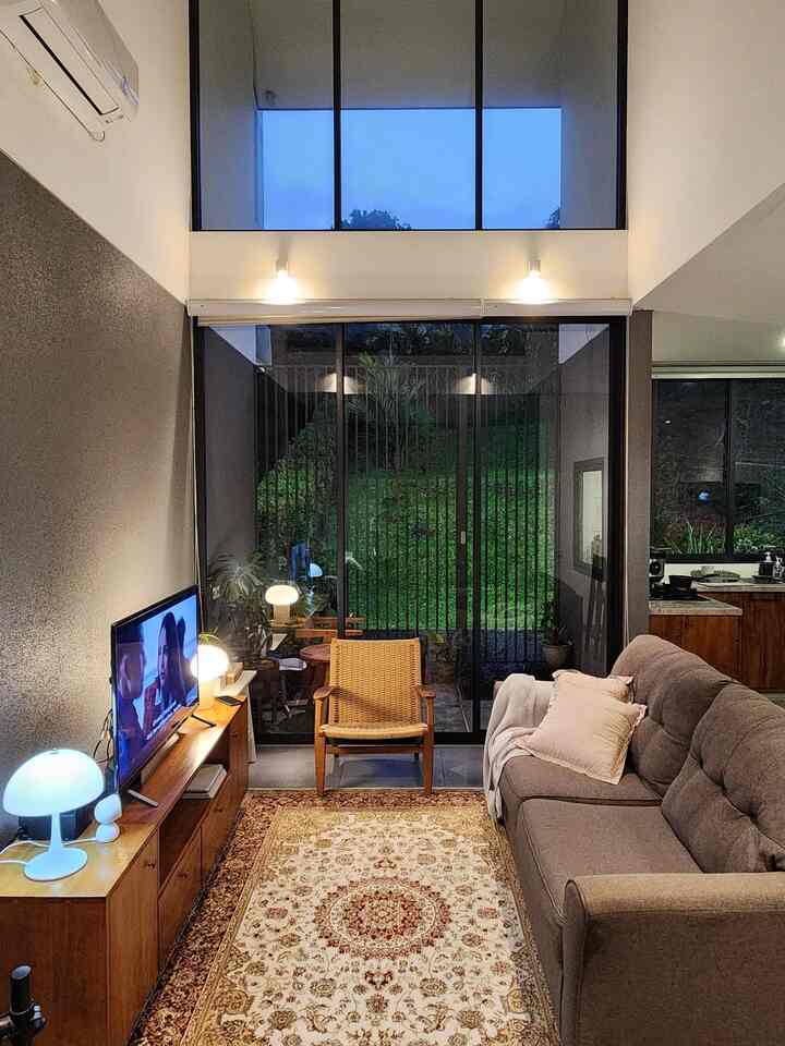 Brown and beige toned living room featuring a large rug, sofa, and wooden armchair creating a cozy atmosphere