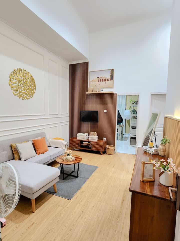 Natural color and wood tone small living room featuring gray sofa and round coffee table with simple, warm ambiance