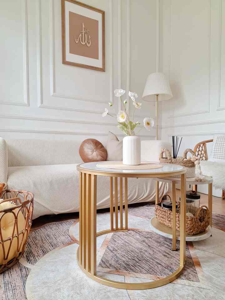 A white and natural tone living room featuring a gold coffee table and vase, creating a cozy atmosphere