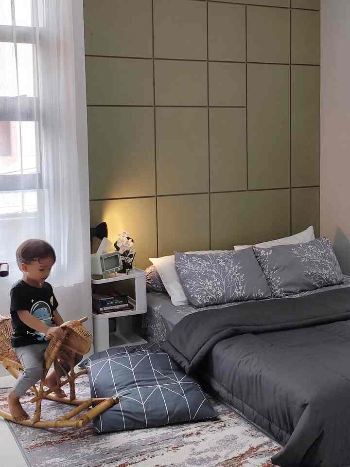 Gray and green toned bedroom featuring a bed and a child's rocking horse in a modern setting