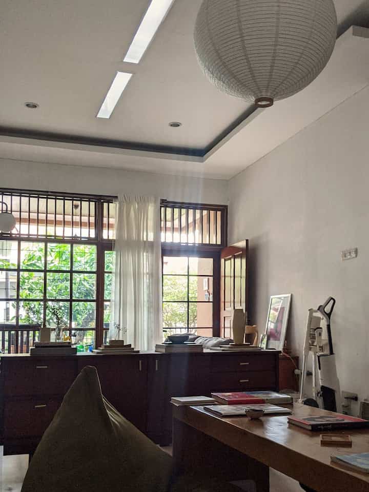 White and brown toned dining room featuring large windows and wooden furniture with a natural atmosphere