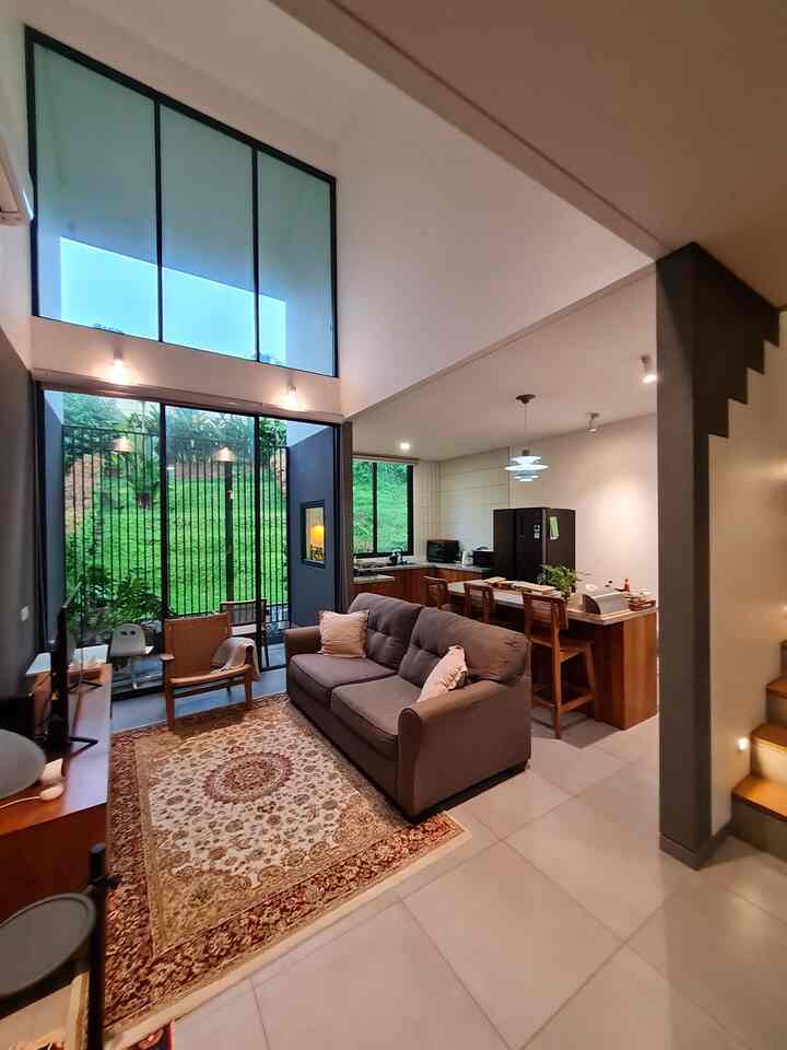 Modern open plan living room and kitchen with natural wood tones and charcoal sofa