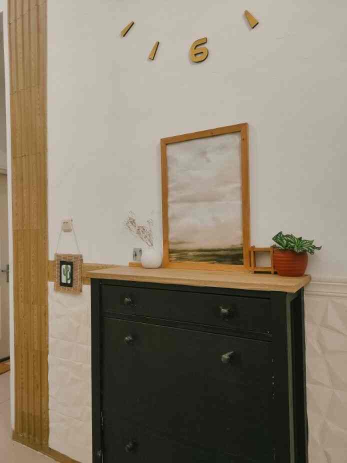 Wood tone and black entrance area featuring wooden framed picture and storage cabinet with calm, natural atmosphere