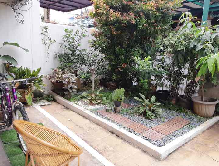 Natural color and wood tone small balcony garden featuring rattan chair in cozy outdoor space