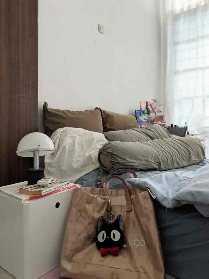Natural brown and blue toned bedroom featuring pillows, bedding, and a cozy atmosphere