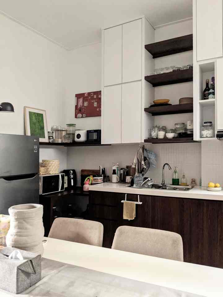 White and brown toned kitchen featuring a picture frame on the wall and beige dining chairs creating a cozy space