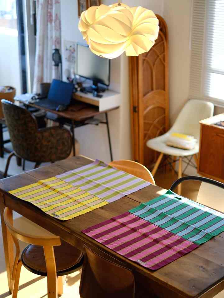 Wood tone and white dining room featuring pendant light and colorful placemats, creating a natural and cozy atmosphere