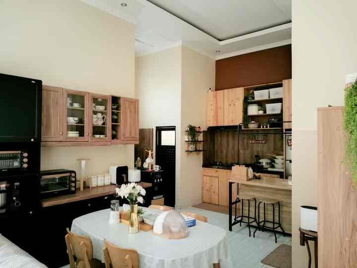 Beige and wood tone kitchen and dining space featuring a wooden dining table with chairs, creating a cozy natural atmosphere