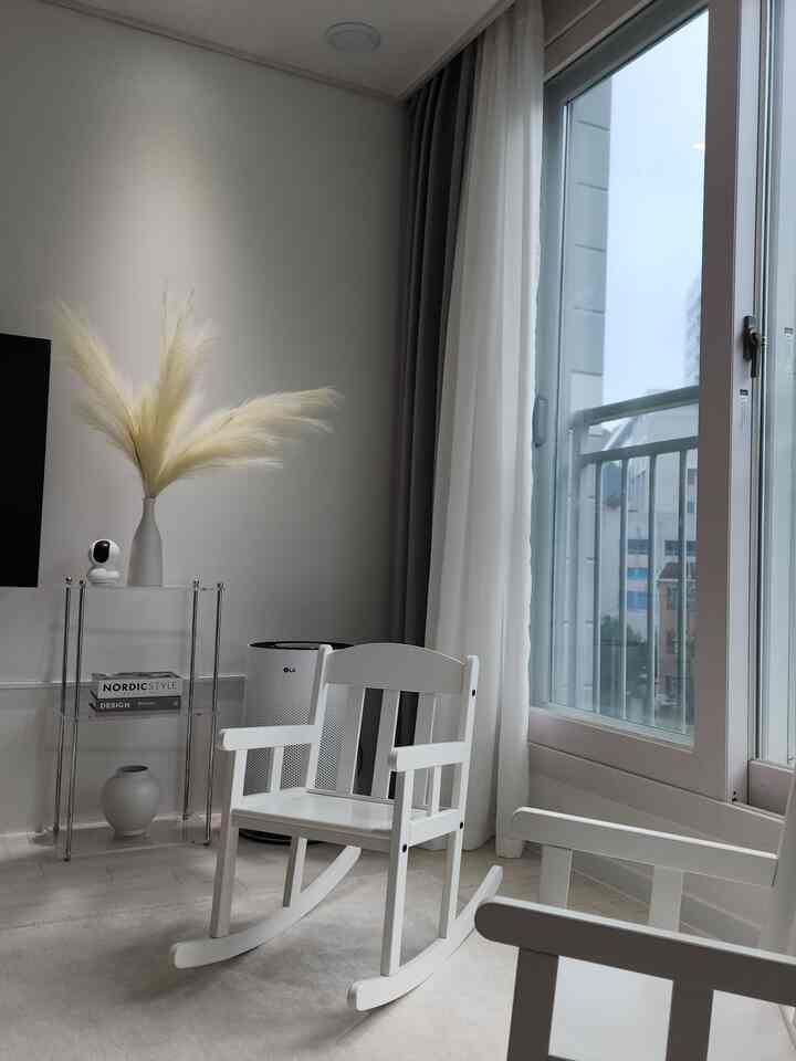 白とナチュラルカラーの子供部屋、スンドヴィクのロッキングチェア2脚と自然素材の装飾が配置された雰囲気のあるインテリア