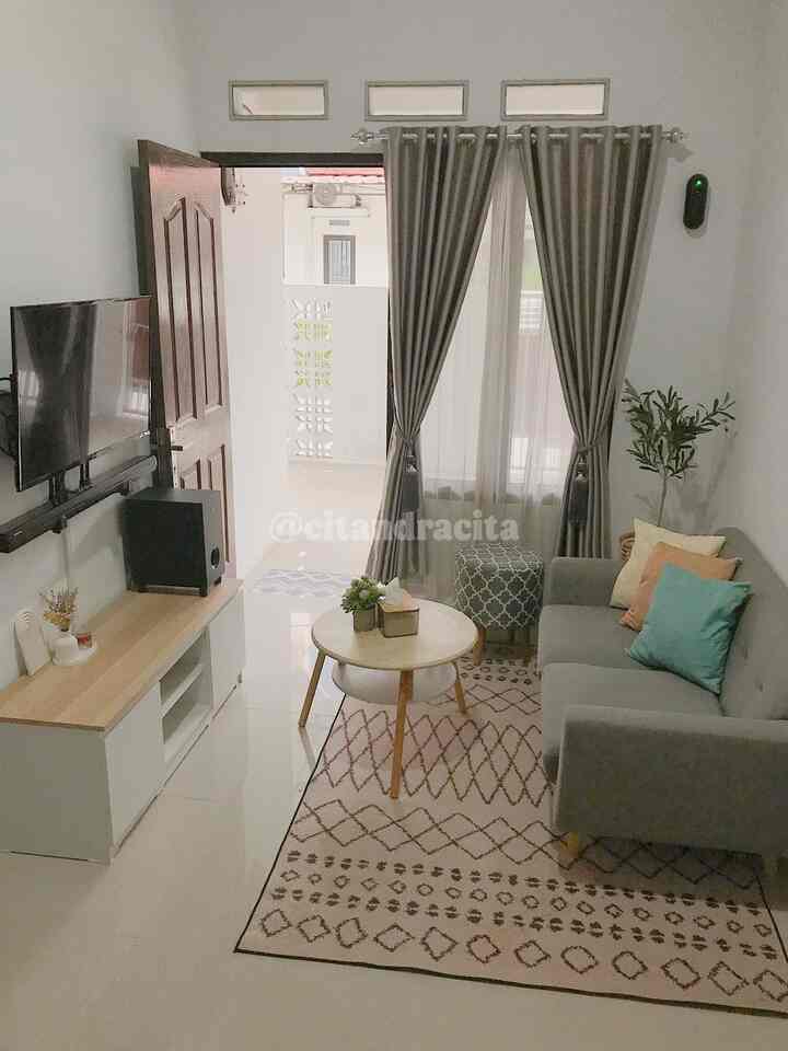 Minimalist living room with a gray curtain and natural wood-toned furniture featuring a gray sofa and patterned carpet