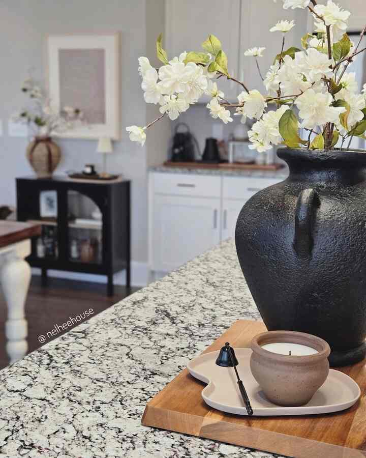 White and black toned kitchen featuring a vase and candle on a natural modern styled countertop