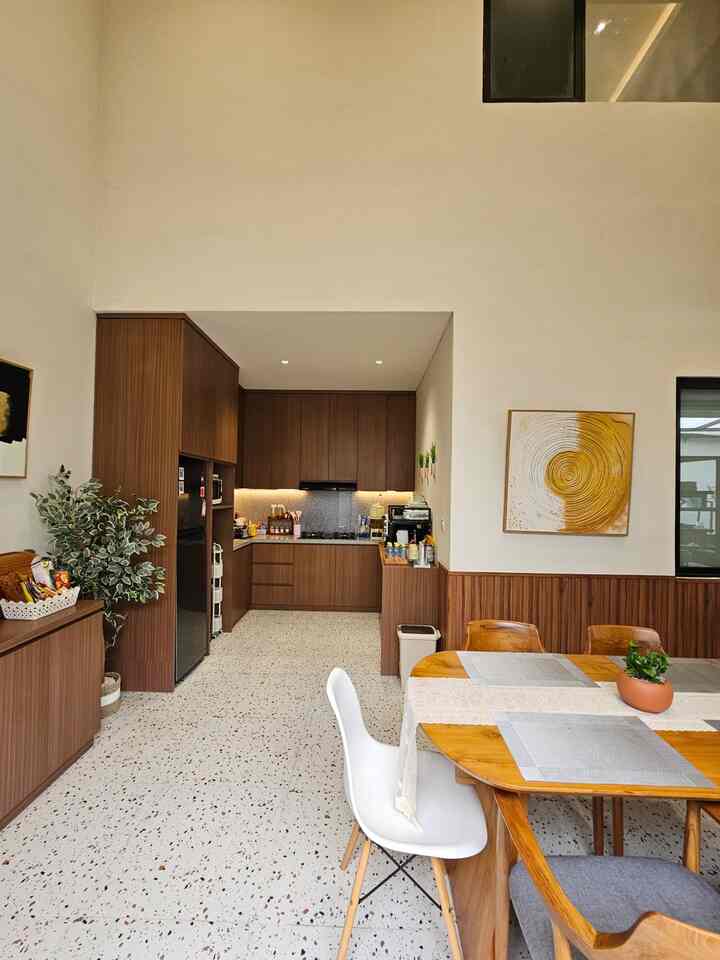 Warm wood tones and white colors blend in a kitchen and dining room space, creating a cozy and clean atmosphere
