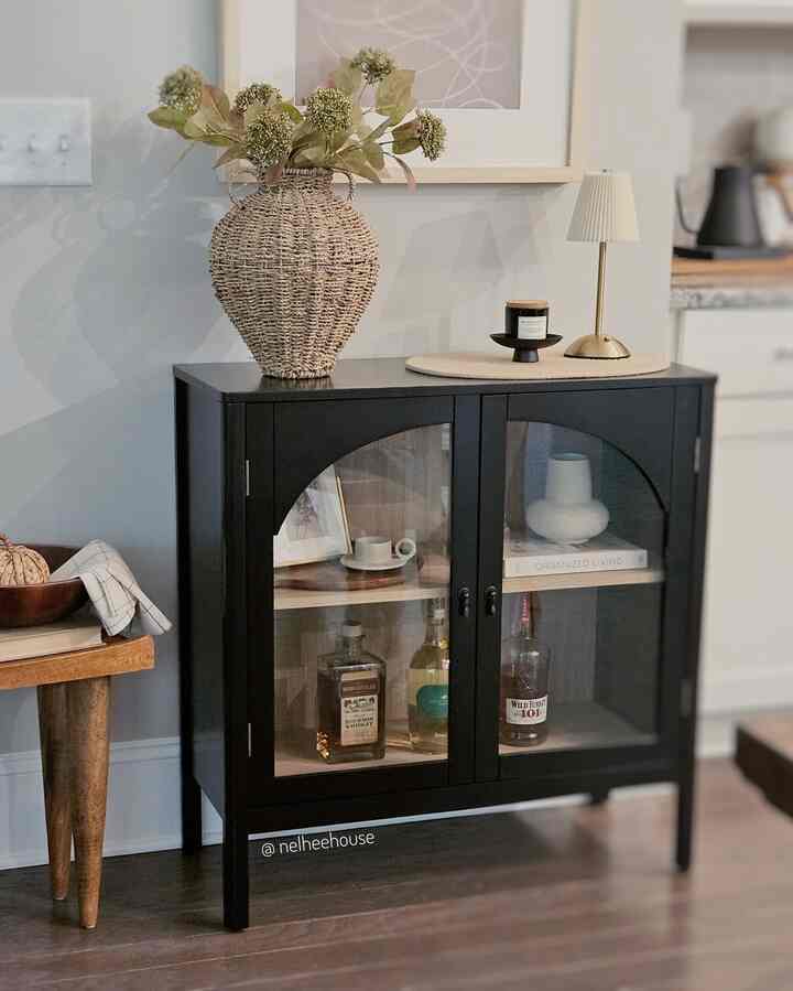 Black modern mid-century bar cabinet with natural decor elements creating a clean home bar space