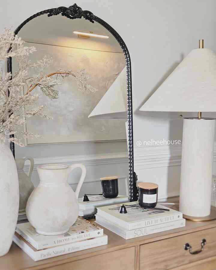 Natural wood tone and beige console table with table lamp in a simple Japandi style entrance space