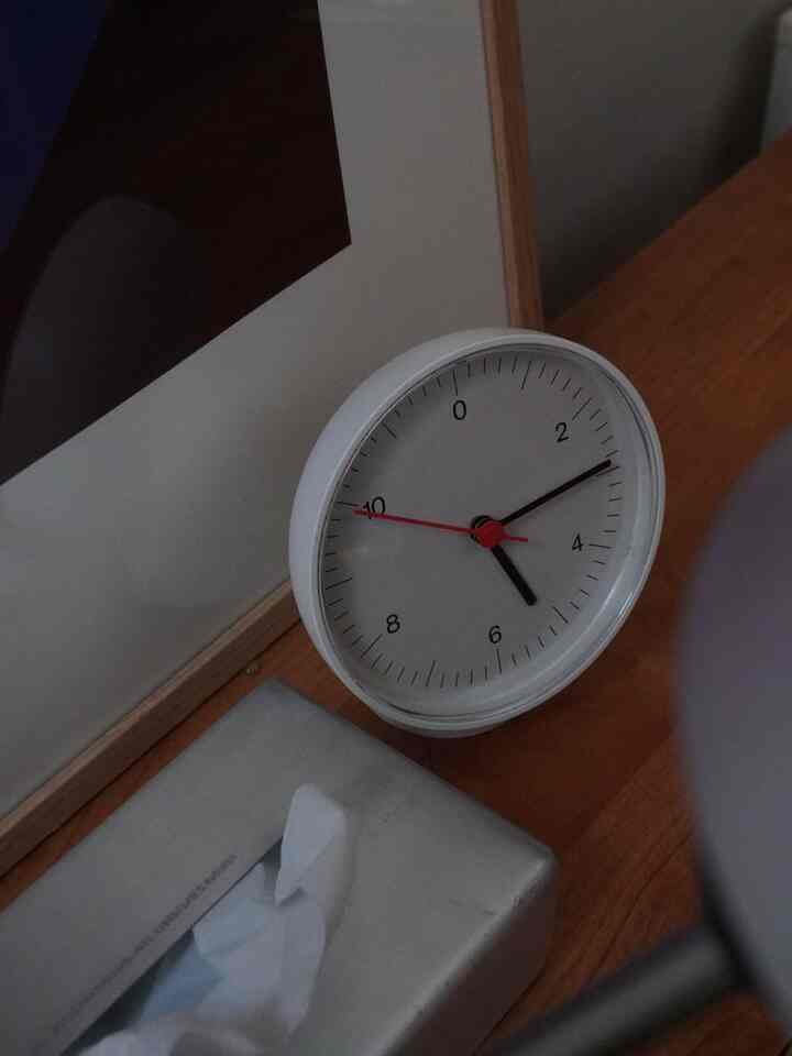 ナチュラルな色調の子供部屋のコーナー、白のHAY置き時計と銀色のティッシュケースが配置されたシンプルな空間