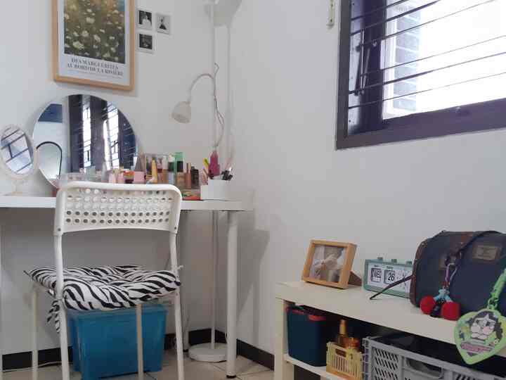 A small white-toned room featuring a vanity desk and chair creating a neat home office space
