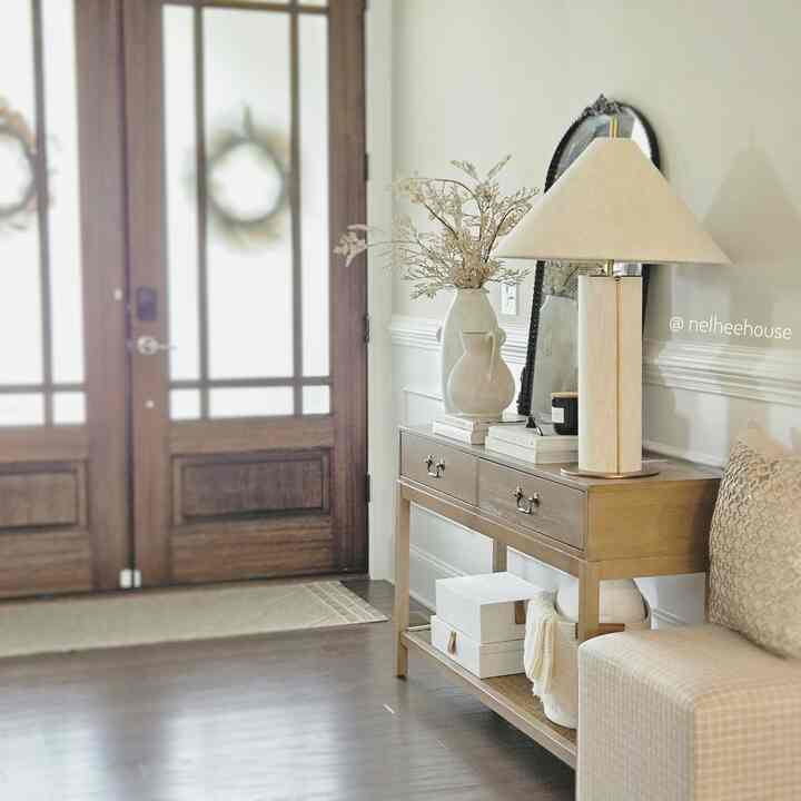 Beige and wood-toned entrance featuring a console table and table lamp creating a cozy atmosphere
