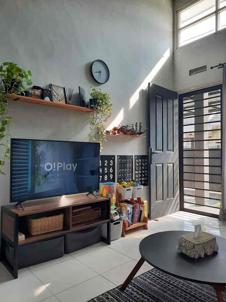 White-walled and floored 3x4m living room featuring black industrial elements, TV stand, and children's toy storage for a neat and functional space