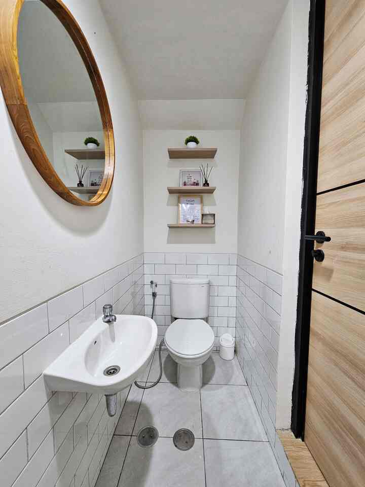 Powder Room mungil berukuran 2.4 x 1 meter ini tidak terlalu sering digunakan, karena memang tidak banyak tamu yang berkunjung ke rumah. Karena itu saya memilih agar powder room ini tetap simple dan minimalis, tanpa terlalu banyak perintilan agar membersihkannya juga lebih mudah. 

Saya tidak mengubah design original dari developer, dan hanya menambahkan beberapa ornamen yang diperlukan seperti cermin dan rak kamar mandi. Agar tidak terlalu polos, saya tambahkan rak ambalan di dinding kosong di atas toilet bowl. 

Powder room ini juga memiliki shower area kecil, karena di lantai dasar juga terdapat satu kamar tamu, sehingga jika ada tamu menginap juga dapat mandi disini. 

Walaupun kecil dan mungil, semoga bisa menginspirasi ya tetangga semua ❤️

#bathroomstyling
#dekorasikamarmandi
#powderroommungil
#rakambalan
#cerminkayujati
#stylingkamarmandi