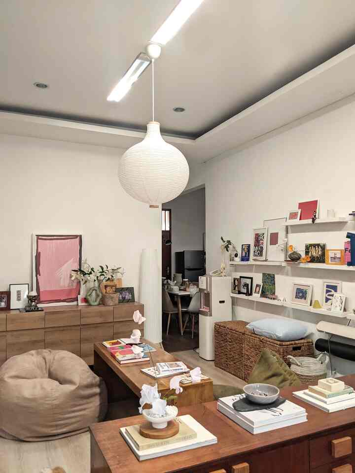 Natural wood tones and beige living room featuring bean bag, storage cabinets, and decorated wall creating a cozy ambiance