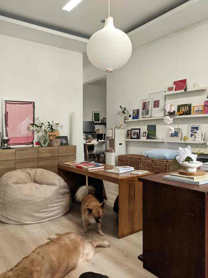 Brown wood tones and white blend in living room featuring a large wooden table, bean bag, and dogs creating a cozy family space