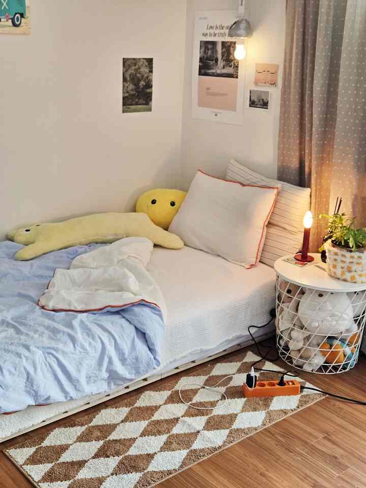 白と茶色の色調の寝室、低いベッドと居心地の良いクッションが配置されたミニマルな雰囲気のインテリア