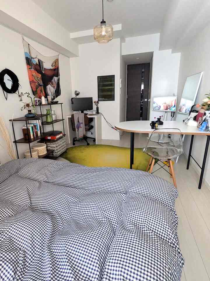 A clean 10-tatami room with white walls and flooring, featuring a bed, desk, semi-circular table, and transparent chair