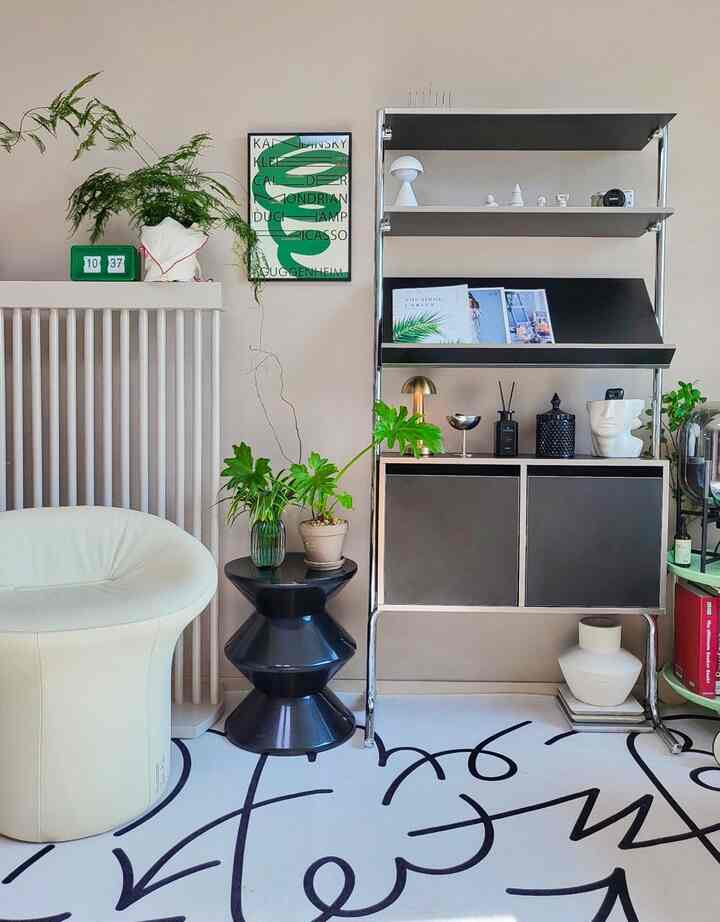 White and black toned living room featuring mid-century modern furniture and plants with a stylish and calm atmosphere