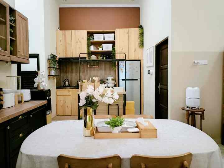 Natural wood tone and white kitchen and dining area featuring a clean, minimalistic atmosphere