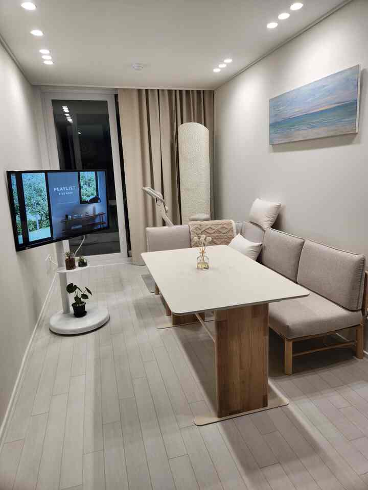 Warm beige curtains and wood tone dining table in a minimal, small living room space