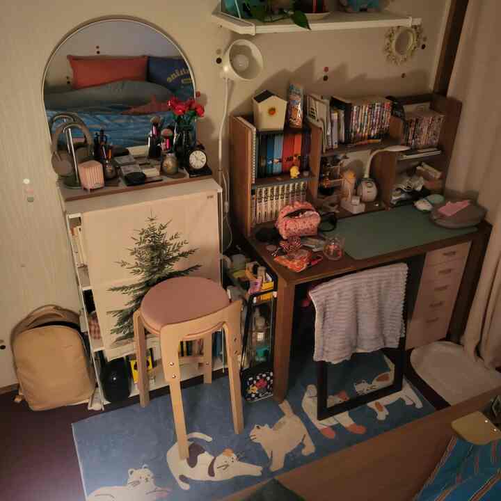 暖かみのあるウッドトーンとナチュラルカラーの居心地の良い書斎、猫柄ラグとミッドセンチュリーモダンの木製家具が配置された空間