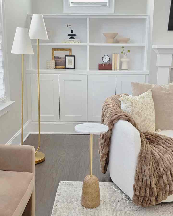 White and beige toned living room featuring an armchair, sofa, and floor lamps with a cozy modern feel