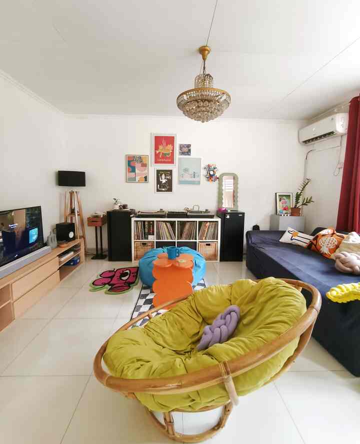 Bright living room with navy sofa, wood tone chair and red curtains
