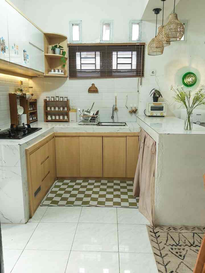 Transformasi Dapur Mini 🏠
Dapur mini yang nyaman di Ryuto house. Walaupun mini tapi compact dengan penambahan kabinet dan desain berbentuk U. Dengan budget yang minim, kami merenovasi dapur agar nyaman digunakan sehari hari. Penambahan kabinet berwarna wood and white yang sedang hits kala itu dan warnanya yang netral sangat cocok di rumah ini. Kami menggunakan backsplash dan table top dari granite berwarna putih. Penambahan wooden blind dan rak kayu sangat cocok dengan konsep dapur yang kami inginkan karna serba natural dan terasa homey. Untuk penerangan di malam hari, kami juga menambahkan lampu ganting dengan kap berbahan rotan

#Mydreamkitchen #kitchenrenovation #kitchenstyling #dapurmini #lampugantung #tabletop #backsplash #dapurimpian