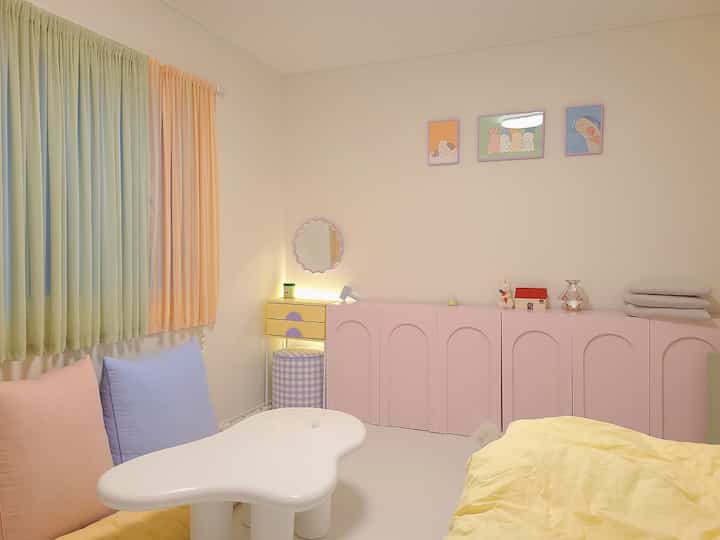 Soft beige and pastel toned bedroom featuring kids' furniture and cute decor in a cozy atmosphere