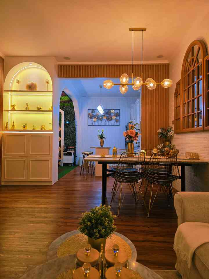 Cozy dining room with warm wood tones, gold lighting fixtures, and white walls harmoniously arranged