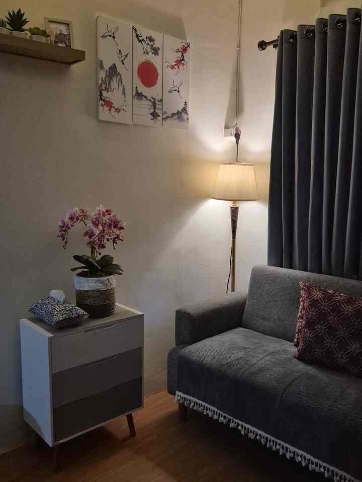 Gray and brown toned living room featuring sofa, lamp, and vase with a cozy atmosphere