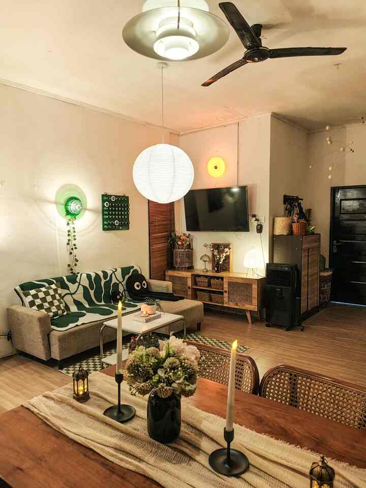 Warmly lit open living and dining area for two featuring wooden furniture and pendant lighting