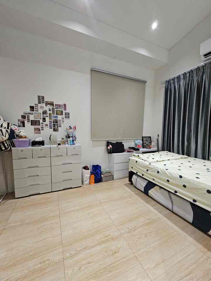 Minimal style bedroom with white walls and wood-tone floor, featuring storage drawers and a monotone roller blind creating a clean space