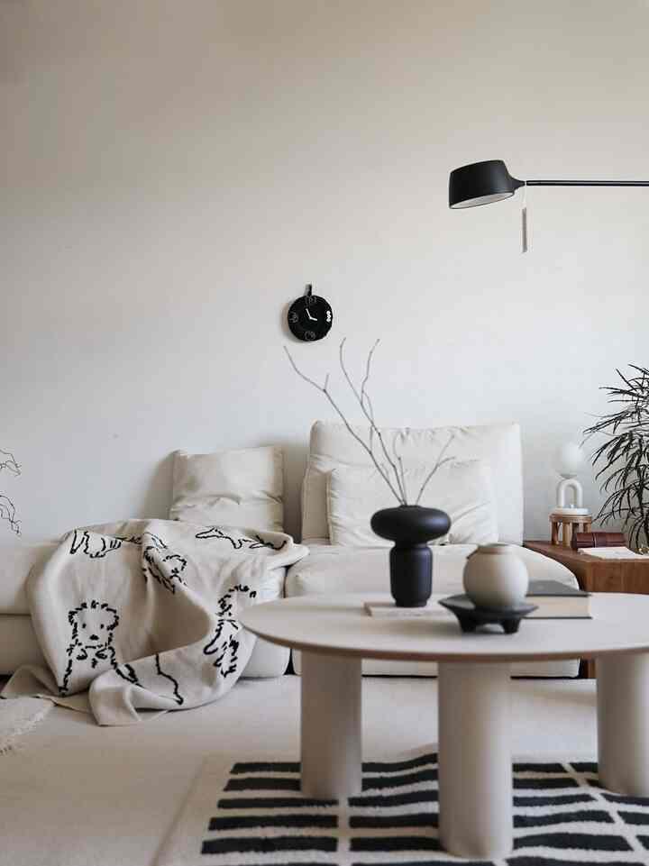 White and black toned living room featuring sofa and coffee table with simple, natural atmosphere