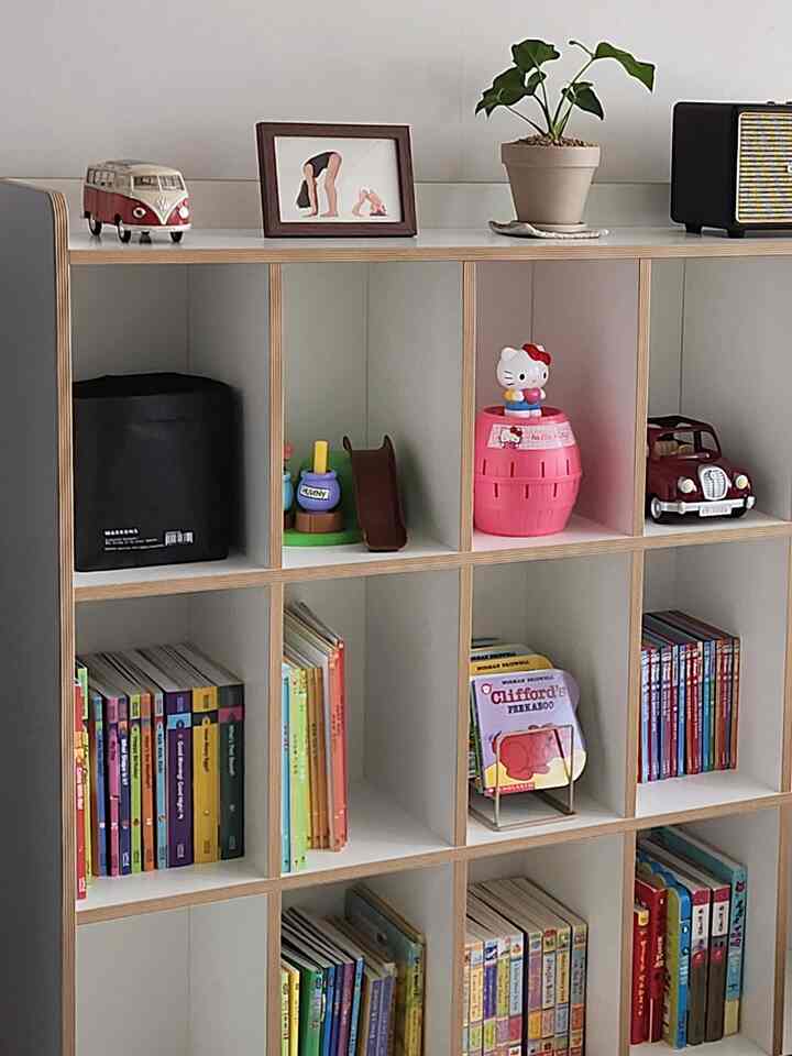 ナチュラルな色調の子供部屋、キューブ型の本棚に子供の本とおもちゃが整然と並べられた雰囲気のあるインテリア