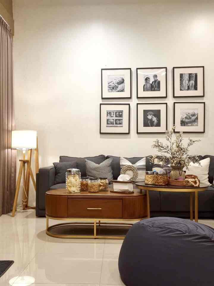 Natural-toned living room featuring gray sofa, wooden coffee tables, and bean bag with warm atmosphere