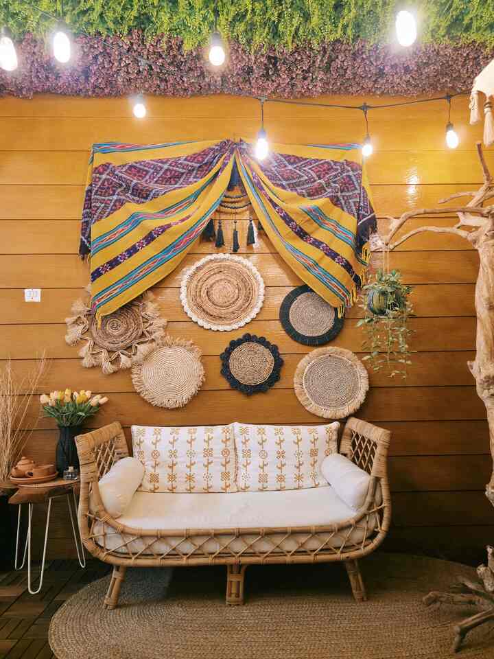 Warm beige natural toned living room featuring rattan sofa and diverse handcrafted woven wall decor creating cozy ambiance