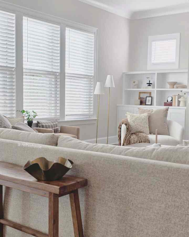 Bright white and beige toned living room featuring sofa, armchair, and floor lamps in a natural modern style