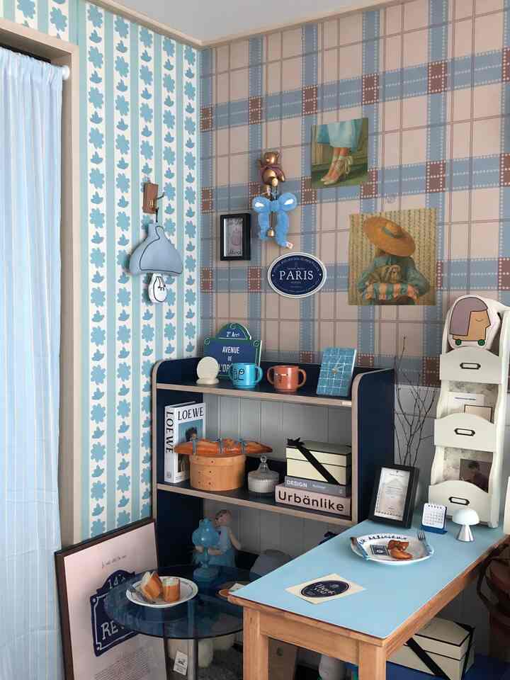 ブルーとベージュのダイニングルーム、書棚とサイドテーブル、コーヒーテーブルが配置された雰囲気のあるインテリア